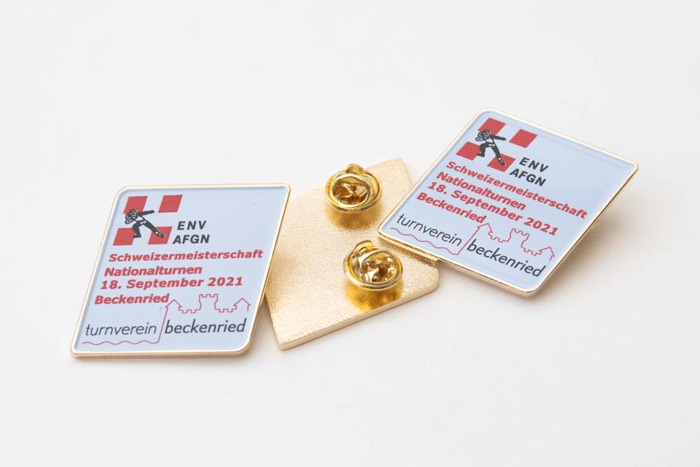 pin-mit-logo-env-schweizermeisterschaft-goldfarbig-juerg-siegrist-ag