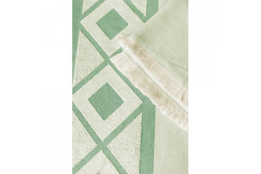 Detail des grünen Hamam Badetuchs mit Baumwollstruktur, geometrischem Muster und Fransen, hochwertiges Werbetextil für Unternehmen - Detailaufnahme